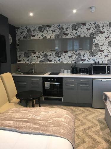 a kitchen with a sink and a stove top oven at Acacia Villas Guest House in Guildford