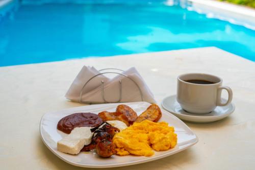 a plate of breakfast food and a cup of coffee at Suites & Apartments San Benito - Zona Rosa in San Salvador