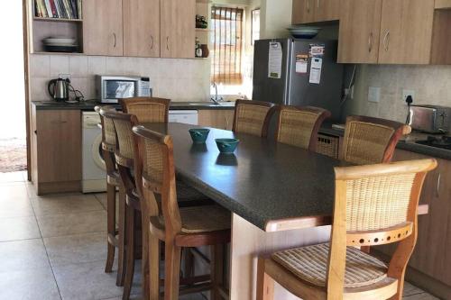 una cucina con tavolo con sedie e frigorifero di Seals Cottage Excellent Main Beach Access a Cape St Francis