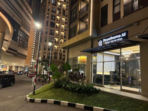 a building with a sign on the front of it at Cozy Furnished Studio Apartemen Transpark Cibubur by Royal Home Indonesia in Kalimanggis