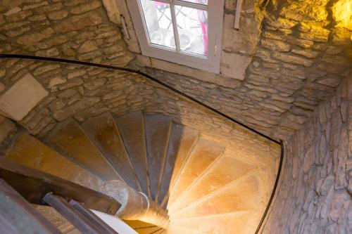 a spiral staircase with a window in a stone building at Residence Beaune Sweet Home, 4 Appartements d'exception avec parking inclus in Beaune