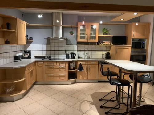 une cuisine avec des armoires en bois et une table à l'intérieur dans l'établissement Grand appartement centre ville, au Creusot