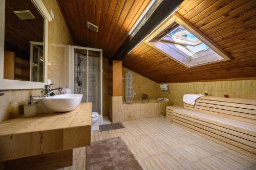 a bathroom with a tub and a sink and a skylight at bed an breakfast Aurora in Trento