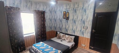 JawāharnagarにあるKeviz Homestayのベッドと窓のある小さな寝室