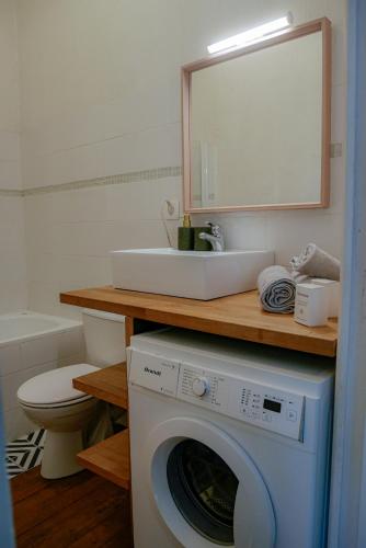 une machine à laver dans une salle de bain avec un lavabo dans l'établissement Volta - T2 à deux pas de la Gare Matabiau, à Toulouse