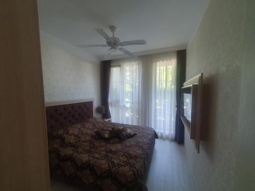 a bedroom with a bed and a ceiling fan at Harmony Suites 11 Grand Resort in Sunny Beach
