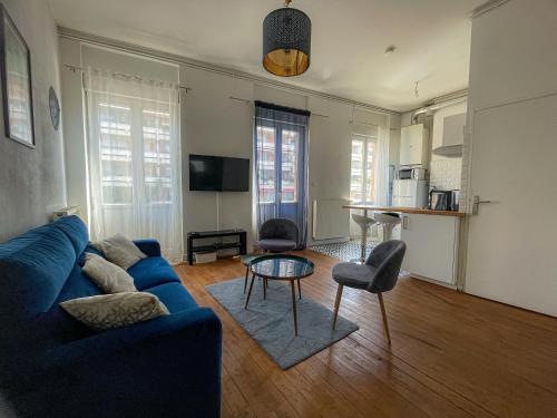 un salon avec un canapé bleu et une table dans l'établissement Volta - T2 à deux pas de la Gare Matabiau, à Toulouse