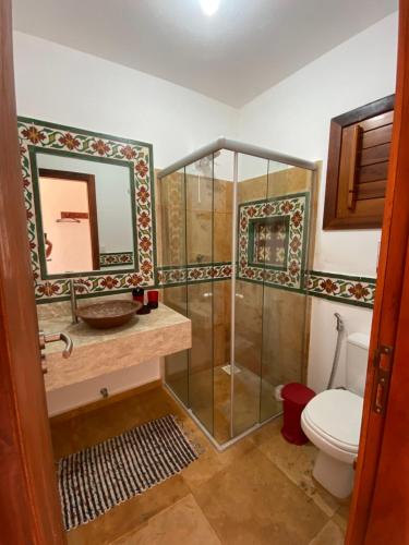 a bathroom with a shower and a toilet at Mansão Guajiru Suítes in Guajiru