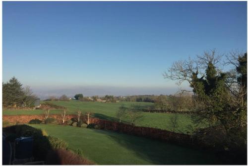 a view of a green field with a fence at Detached loft, stunning city views in Drumbo