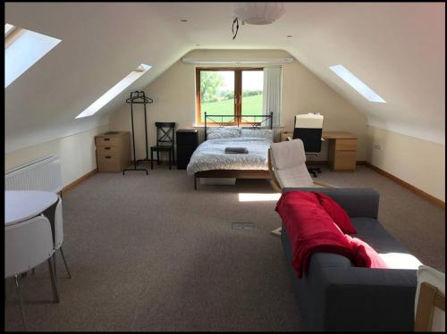 a attic room with a bed and a couch at Detached loft, stunning city views in Drumbo