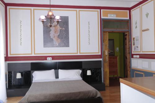 a bedroom with a bed and a chandelier at B&B "Domus Atilia" in Sagunto