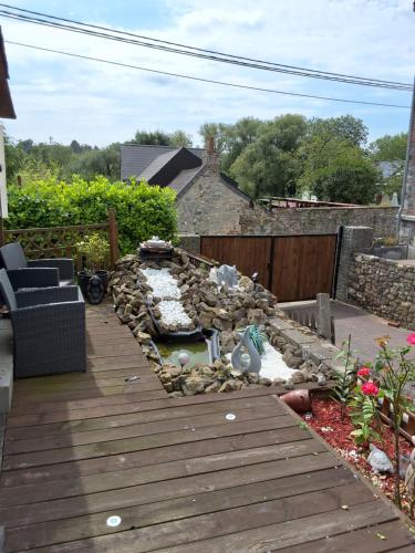 a backyard with a wooden deck with a rock garden at Le petit nid in Brugelette