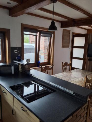 a kitchen with a black counter top and a stove at Le petit nid in Brugelette