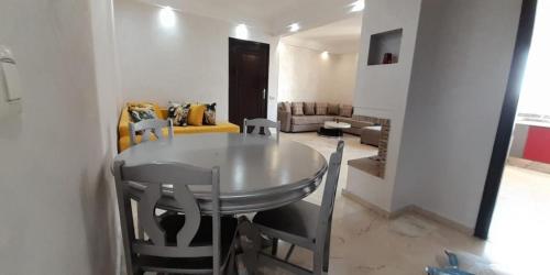 a living room with a table and chairs and a couch at EuroStar Appartement in Casablanca