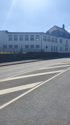 an empty road in front of a white building at Zur Schlinge in Siebenhitz