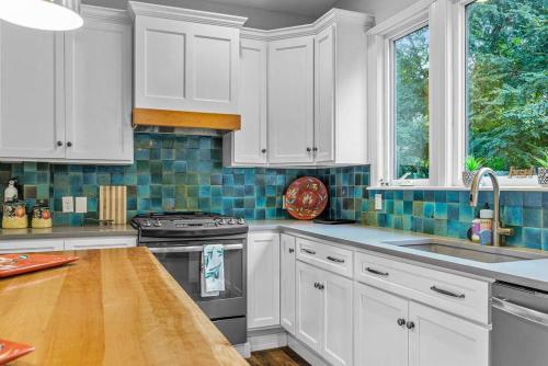 a kitchen with white cabinets and a sink and a stove at Fantastic Family Home in Central Mount Washington in Pittsburgh