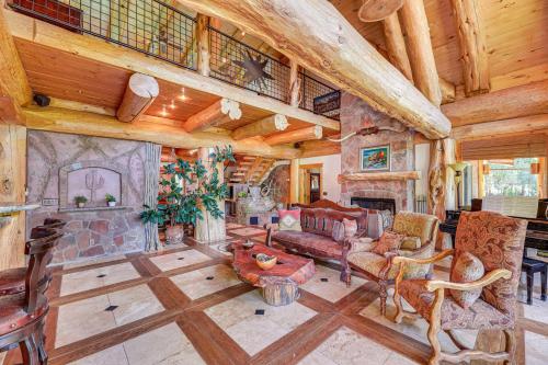 a living room filled with furniture and a stone fireplace at Scenic Payson Cabin with Wraparound Patio in Payson