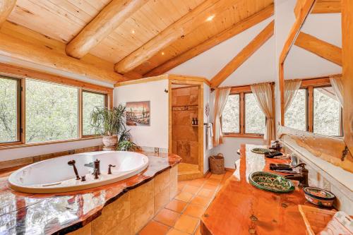 a bathroom with a large tub in a room with wooden ceilings at Scenic Payson Cabin with Wraparound Patio in Payson