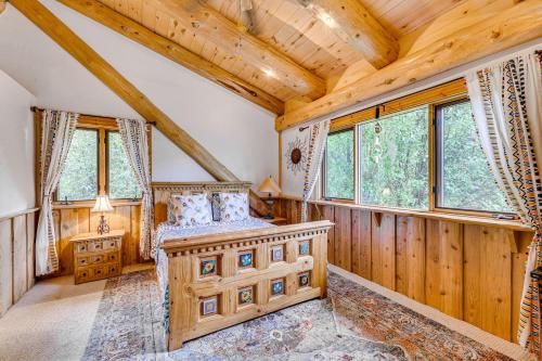 a bedroom in a log cabin with a bed and windows at Scenic Payson Cabin with Wraparound Patio in Payson