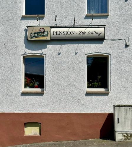 a building with two windows and a sign on it at Zur Schlinge in Siebenhitz