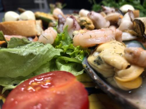 a salad with shrimp and lettuce and a tomato at Fachwerk-Hotel Eisenbart in Hannoversch Münden