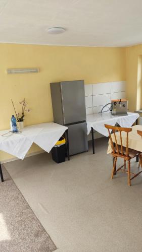 a room with two tables and a refrigerator at Zur Schlinge in Siebenhitz