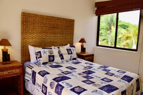 a bedroom with a blue and white bed with a window at VillaFV GuavaBerry-JuanDolio-4BR-6Bds-12Pax-AC-WiFi-BBQ-GolfView in Paraíso