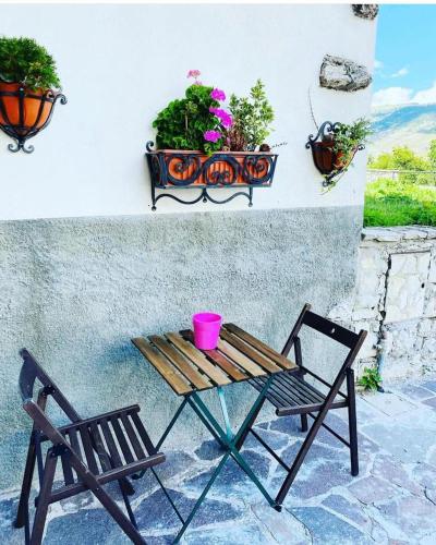 a bench and a table and a chair and flowers at La casa di Teo Pescocostanzo in Pescocostanzo
