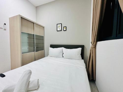 a bedroom with a white bed and a cabinet at The Sun 1 or 3BR Bayan Lepas 4 to 10 pax WL in Bayan Lepas