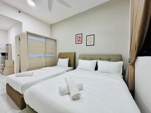 two beds in a room with white sheets and towels at The Sun 1 or 3BR Bayan Lepas 4 to 10 pax WL in Bayan Lepas