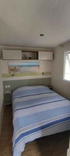 - une chambre dotée d'un lit avec des draps bleus et blancs dans l'établissement Bungalow confortable à Angles avec piscine partagée, à Angles