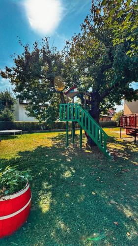 a playground with a green slide in a park at StoneMlynska 7 Slovakia in Svit