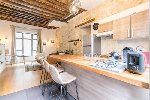 - une cuisine avec un comptoir et des chaises dans la chambre dans l'établissement Cœur de Voltaire - Loft cosy Parisien, à Paris