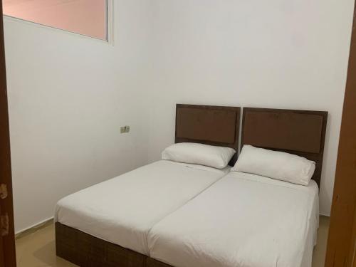 a bed with two white pillows in a room at شقة مفروشة in Beni Enzar