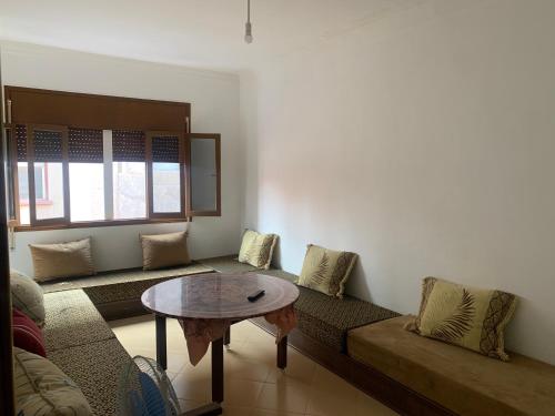a living room with a couch and a table at شقة مفروشة in Beni Enzar