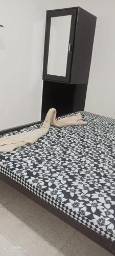 a bed next to a black and white bed frame at Sai Palace in Agra