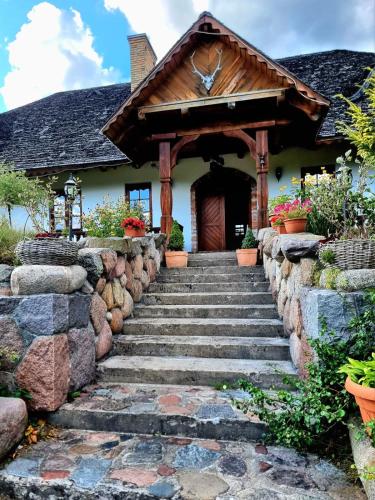 a stone stairway leading to a house with a wooden door at Dworek Mieldziczowka in Supraśl