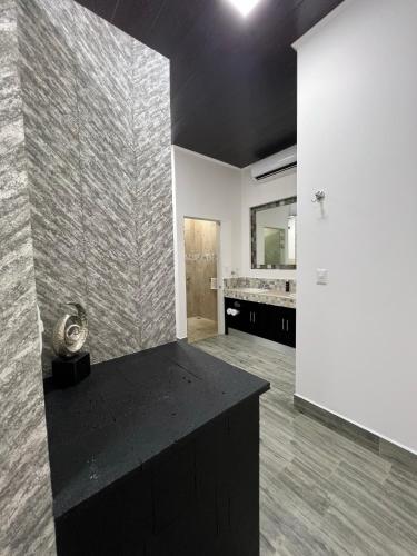 a large bathroom with a black counter and a sink at Hotel Boutique Casa Del Rio in Fortuna