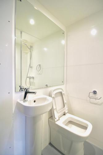 a white bathroom with a sink and a toilet at NE1 City Studios & Apartments in Newcastle upon Tyne