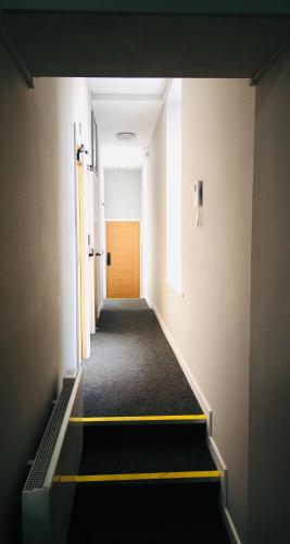 an empty hallway with a yellow door in a building at NE1 City Studios & Apartments in Newcastle upon Tyne