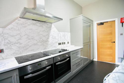 a kitchen with a sink and a stove at NE1 City Studios & Apartments in Newcastle upon Tyne