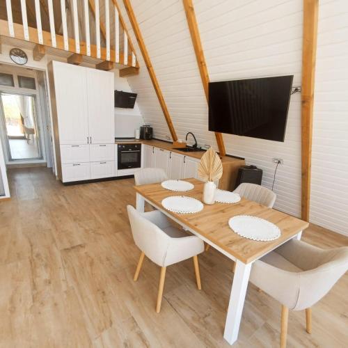 a kitchen and dining room with a wooden table and chairs at Mareva House A Frame Chalet in Râmnicu Vâlcea