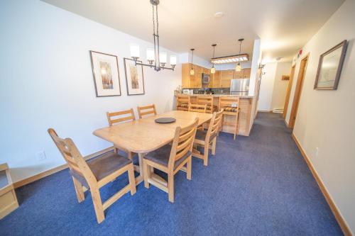 a dining room and kitchen with a wooden table and chairs at Ski Run 202 by SummitCove Lodging in Keystone