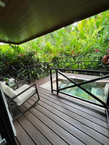 a deck with a chair and a glass table at Hotel Boutique Casa Del Rio in Fortuna
