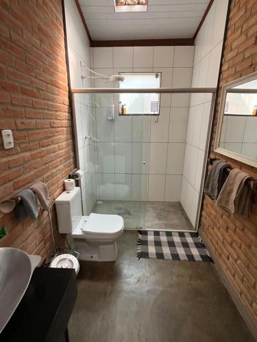 a bathroom with a shower and a toilet and a sink at Refugio do Amor in São João del Rei