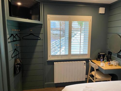 a bedroom with a bed and a window and a desk at The Lemon Leaf Café Bar and Townhouse in Kinsale