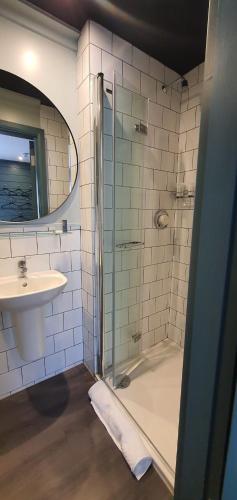 a bathroom with a glass shower and a sink at The Lemon Leaf Café Bar and Townhouse in Kinsale