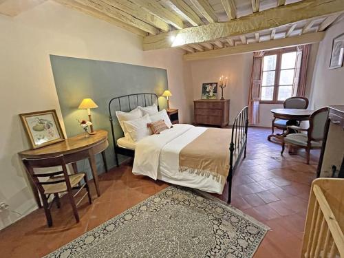 une chambre avec un lit, une table et des chaises dans l'établissement Maison Loumio - Charming 4 double bedrooms village home -ultra fast wifi, à Aups