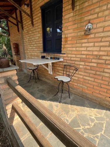 a picnic table and a chair on a patio at Refugio do Amor in São João del Rei