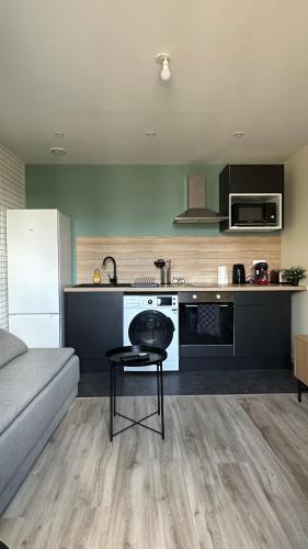 un salon avec un canapé et une cuisine dans l'établissement Appartement Cosy Clinique Mathilde, à Rouen